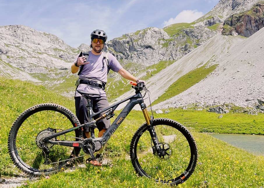 Bikeguide Sämi mit e-MTB am Partnunsee in der Nähe von St. Antönien auf der Biketour zur Carschinahütte in Graubünden.